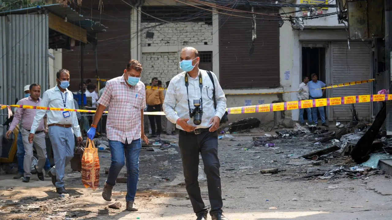 Forensic officials leave the site of a fire at a hotel in the Malviya Nagar area. Pic/PTI